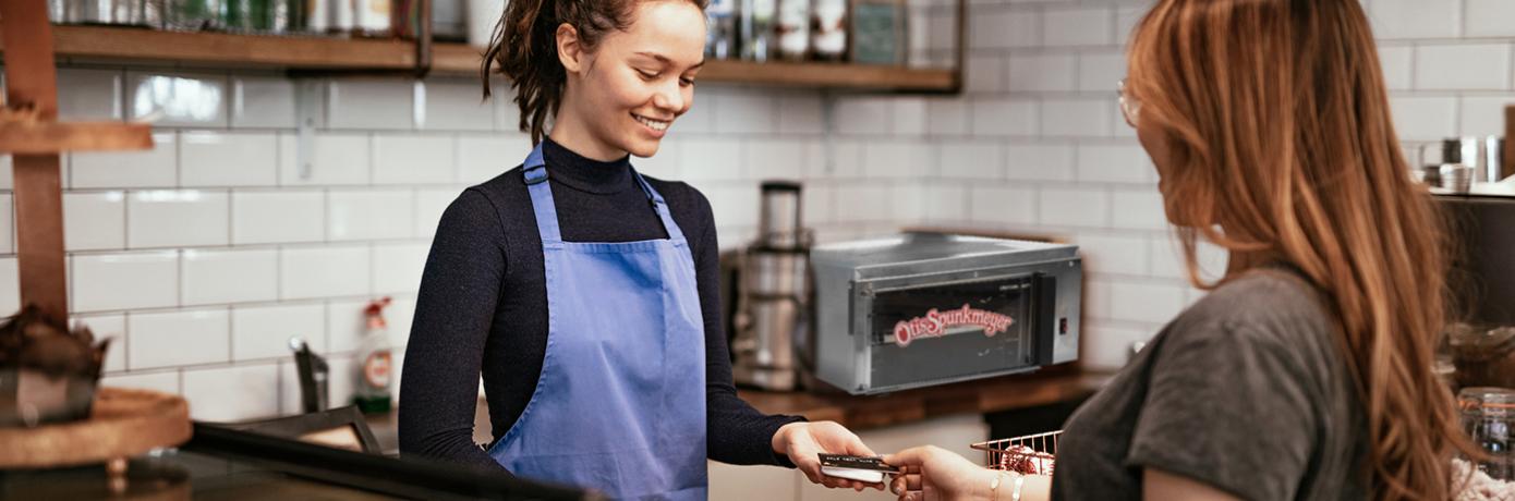 store worker and customer paying