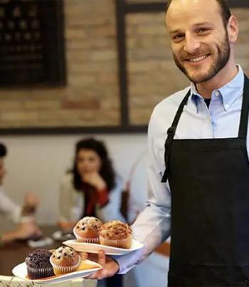 restaurant server holding plates of muffins