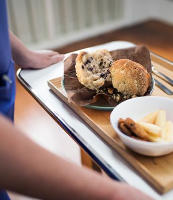 hospital worker bringing tray of food